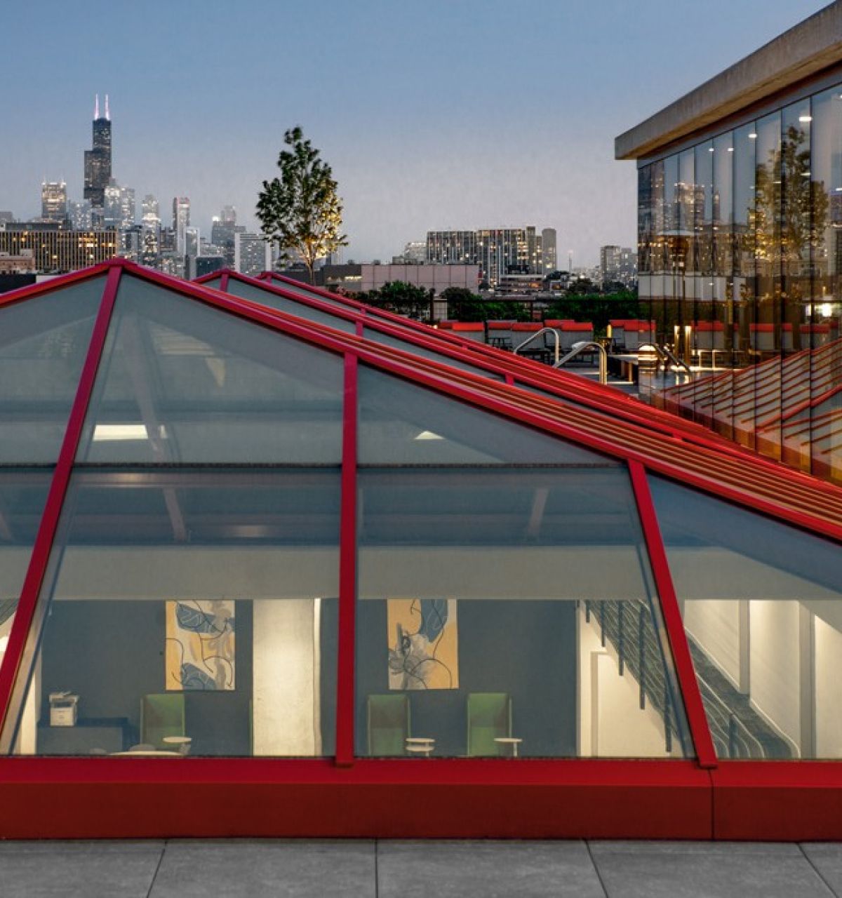 A glass-roofed building by Optima® Living with city skyline at dusk, reflecting everyday beauty through thoughtful design.