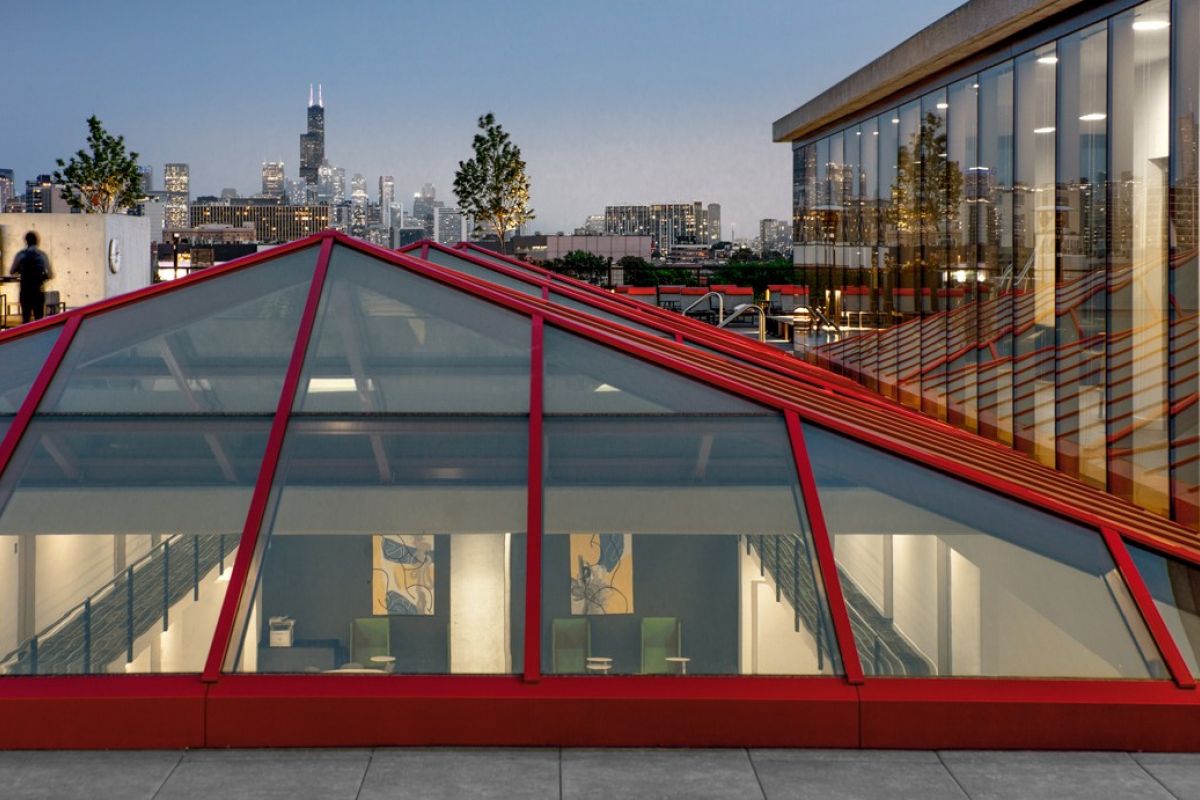 A glass-roofed building by Optima® Living with city skyline at dusk, reflecting everyday beauty through thoughtful design.