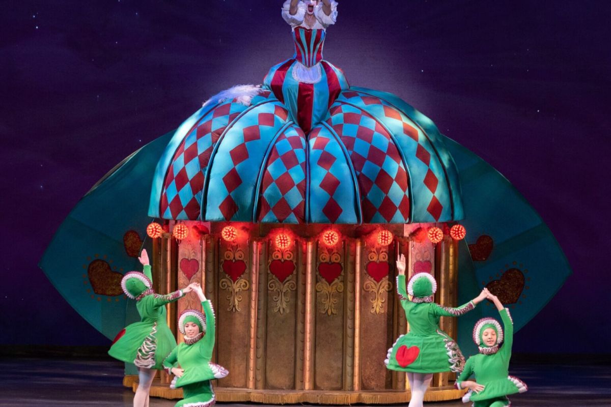 Four dancers in green costumes perform before a colorful, dome-shaped stage in Ballet Arizona’s The Nutcracker, a beloved holiday tradition.