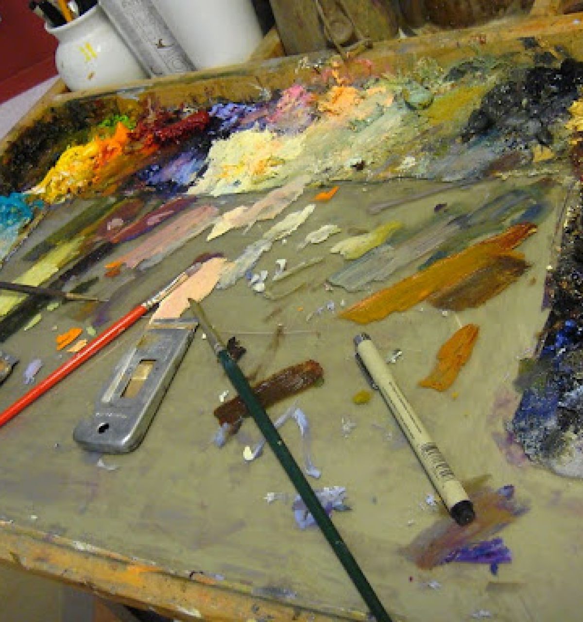 A painter’s palette with mixed colors, brushes, and tools evokes the spirit of a Celebration of Fine Art in Scottsdale.
