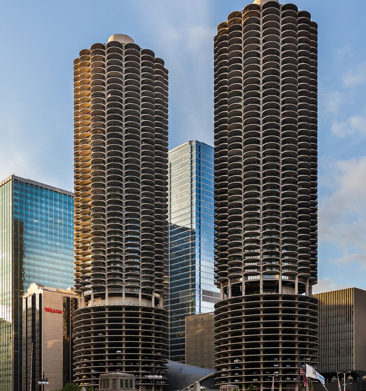 Two round, twin skyscrapers with scalloped balconies in downtown Chicago, surrounded by modern buildings.