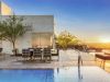 Rooftop pool and patio with modern seating at sunset, overlooking scenic mountains—perfect for those shaping sustainable futures.