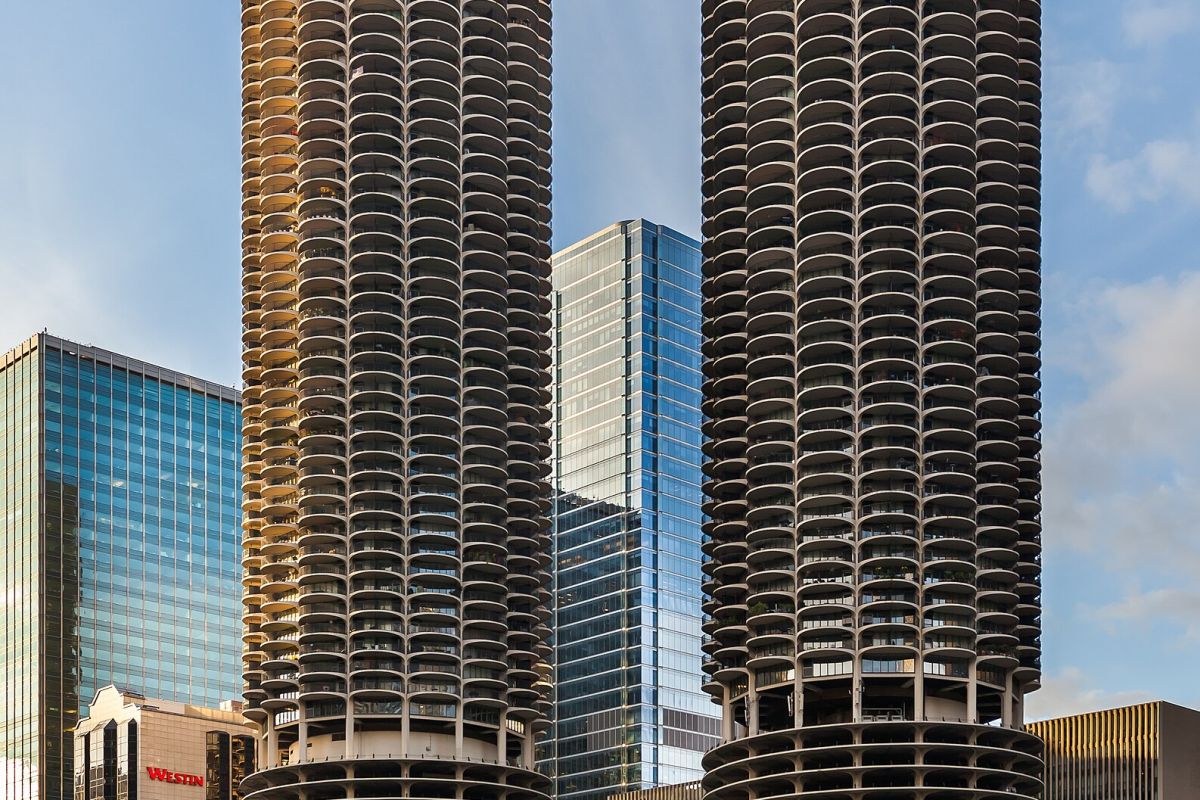 Two round, twin skyscrapers with scalloped balconies in downtown Chicago, surrounded by modern buildings.