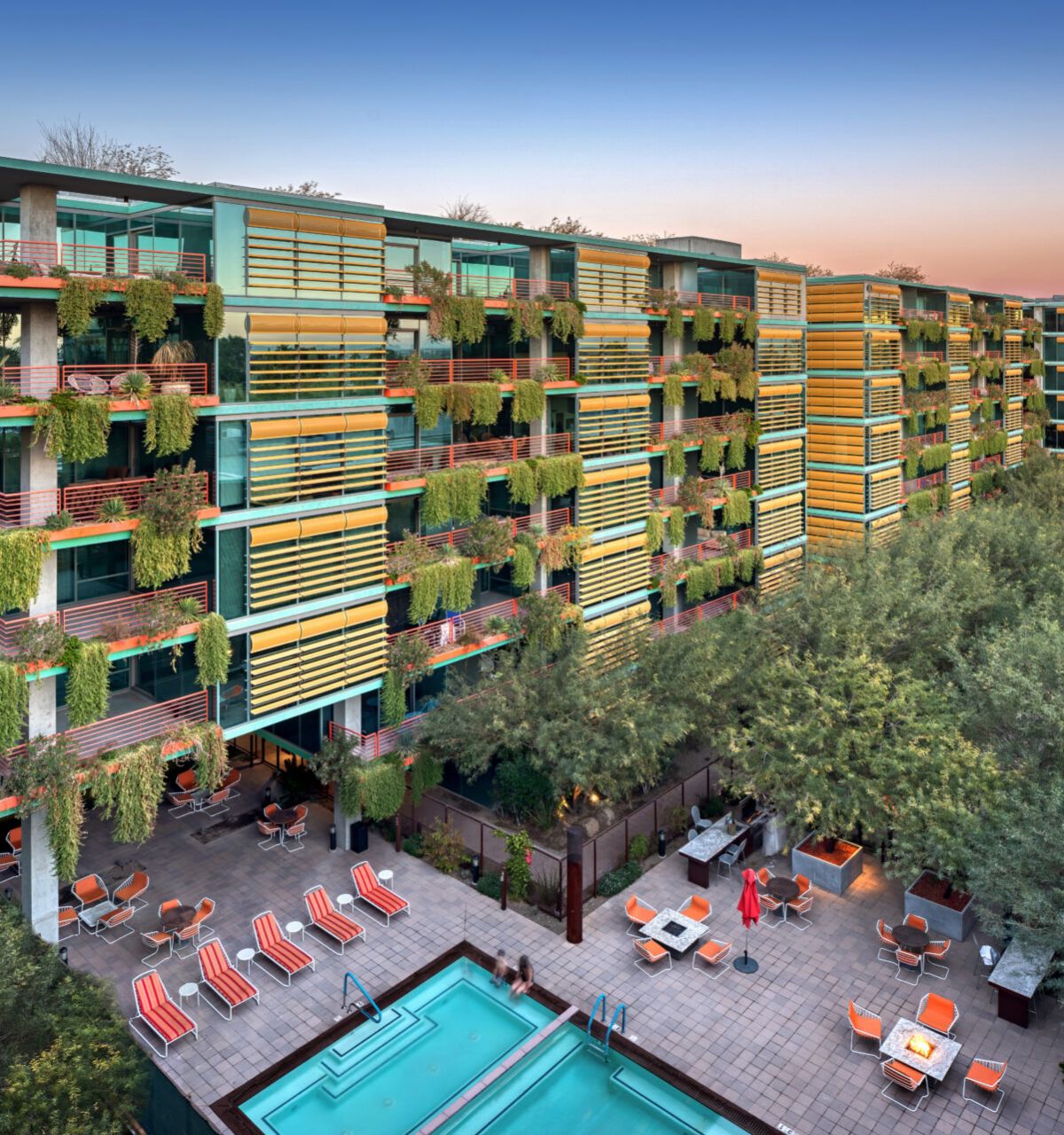 Modern Scottsdale apartment complex with green balconies, a pool area, and easy access to the city's best restaurants nearby.