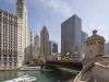 A tour boat glides through the Chicago River, blue space and downtown skyscrapers inspiring mental wellness under a clear sky.