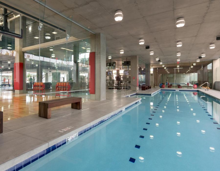 Indoor sports complex with a swimming pool, basketball court, and fitness area at Optima Sonoran Village apartments.