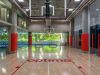 Indoor basketball court with “optima” on the floor and large windows—where spontaneous wellness meets sport amid lush green views.