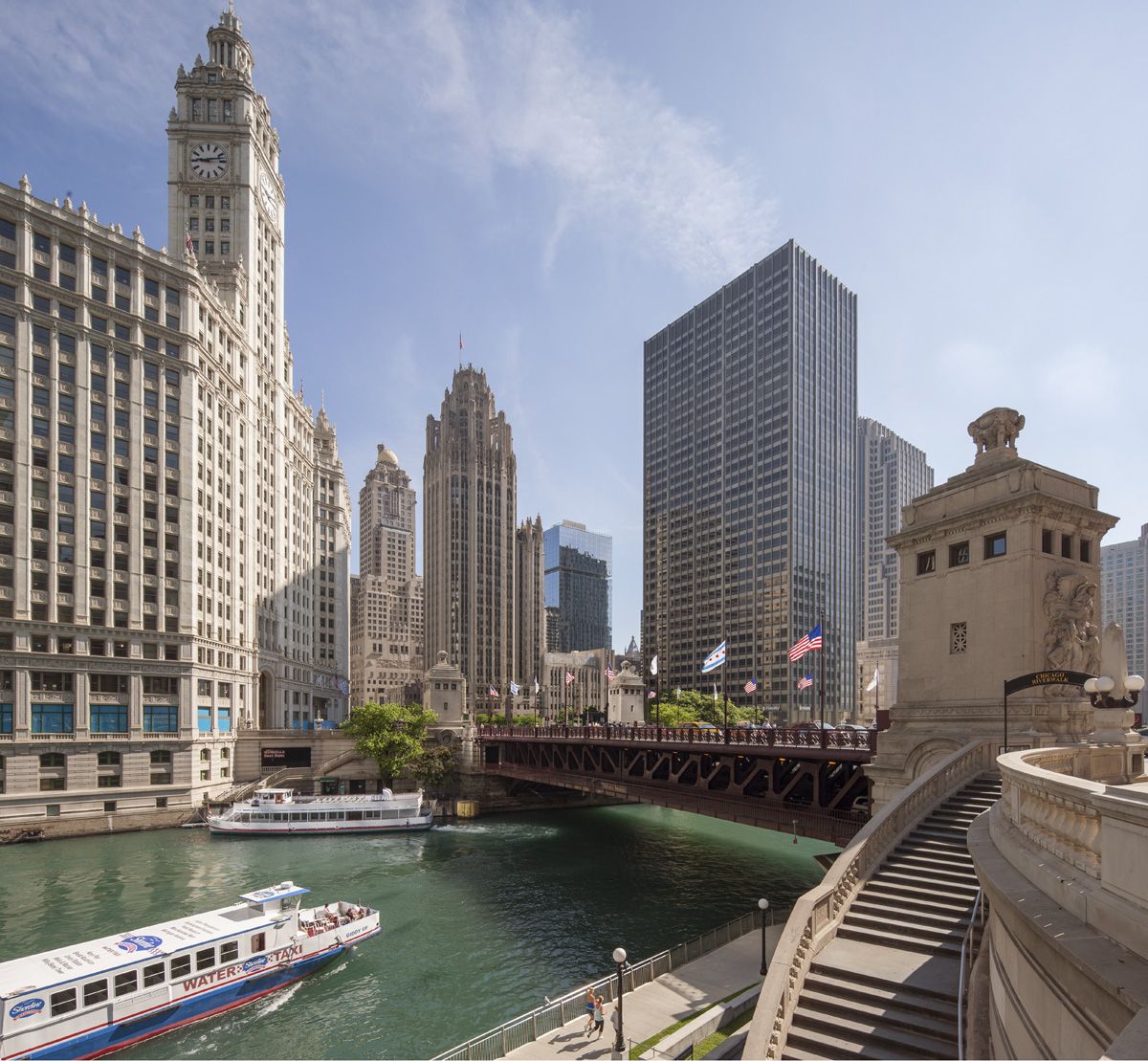 A tour boat glides through the Chicago River, blue space and downtown skyscrapers inspiring mental wellness under a clear sky.