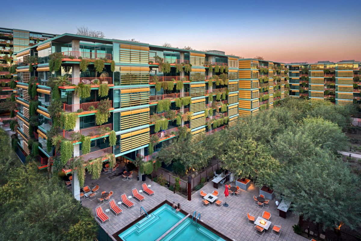 Modern Scottsdale apartment complex with green balconies, a pool area, and easy access to the city's best restaurants nearby.