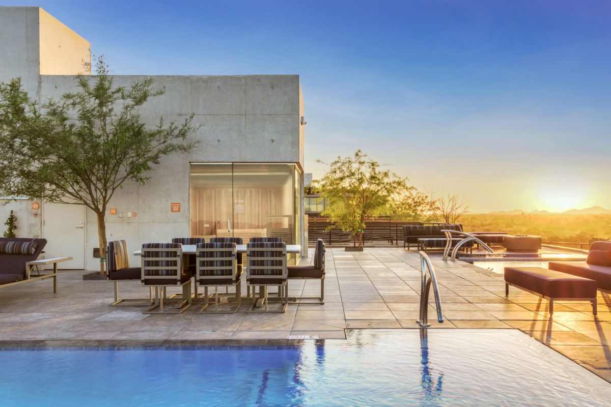 Rooftop pool and patio with modern seating at sunset, overlooking scenic mountains—perfect for those shaping sustainable futures.