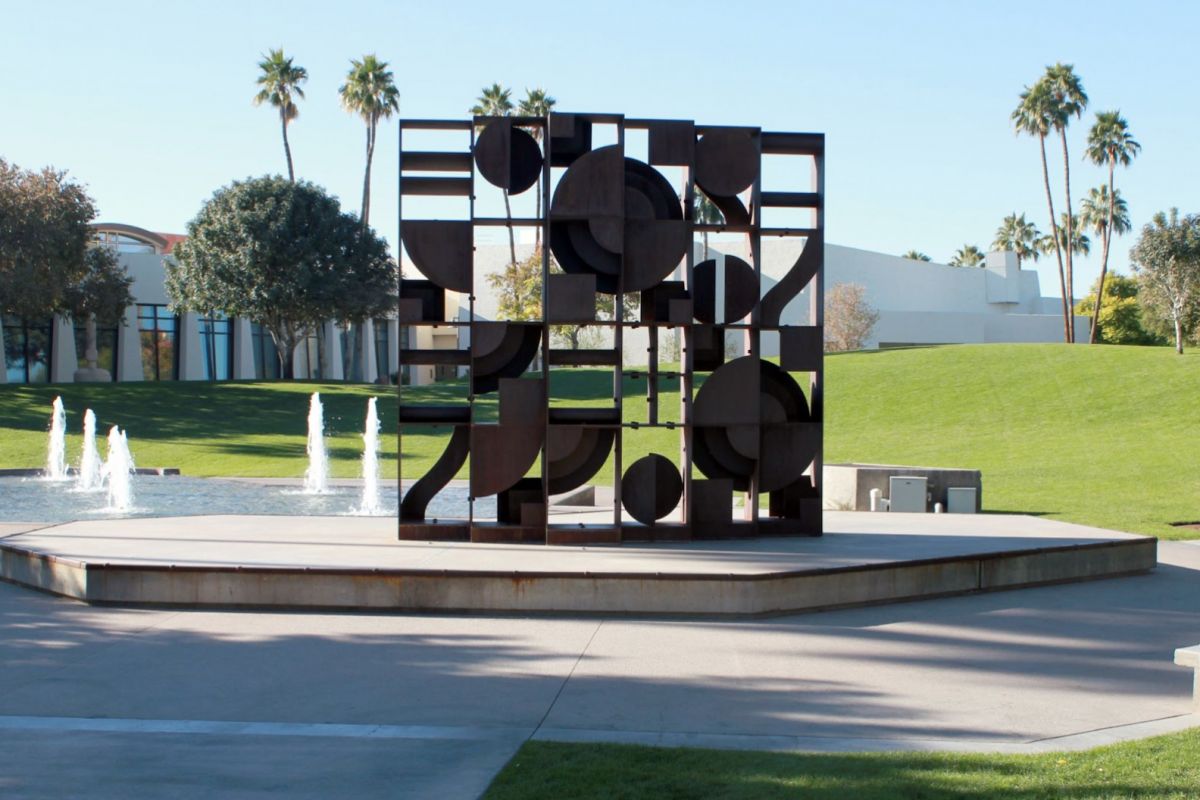 Large geometric metal sculpture, Windows to the West, features circles and squares near fountains and green lawn in Scottsdale.